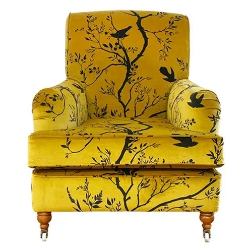 Yellow armchair with black tree and bird design.