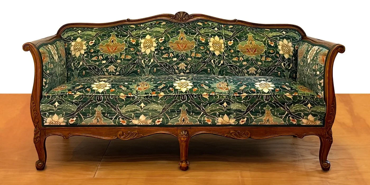 Antique wooden framed sofa with green floral upholstery