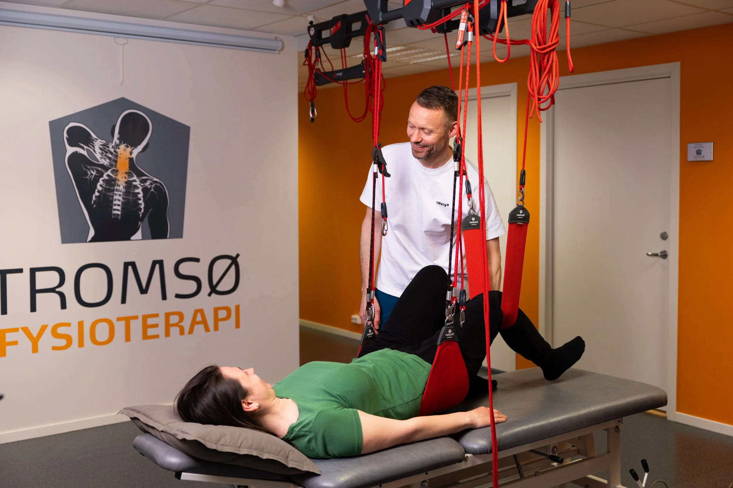 Pasient trener i Redcord-slynger under Neurac slyngebehandling med fysioterapeut
