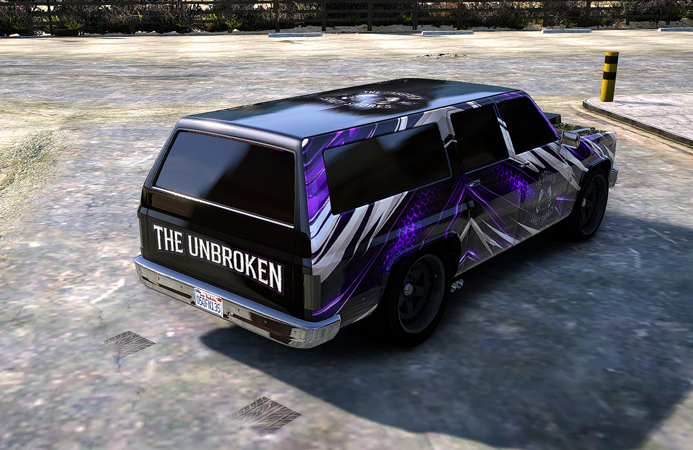A black and purple sports utility vehicle with the words "THE UNBROKEN" on the back, parked in an empty lot.