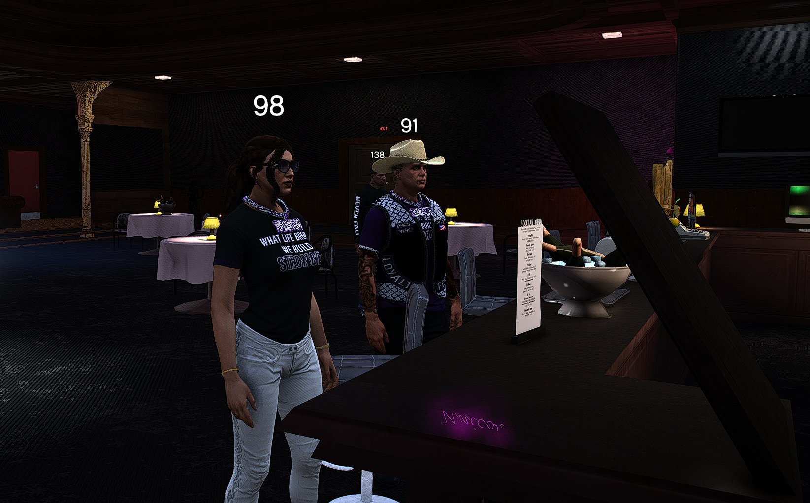 Two characters inside a restaurant or event space, standing at a counter, with tables set with white tablecloths and lamps in the background.