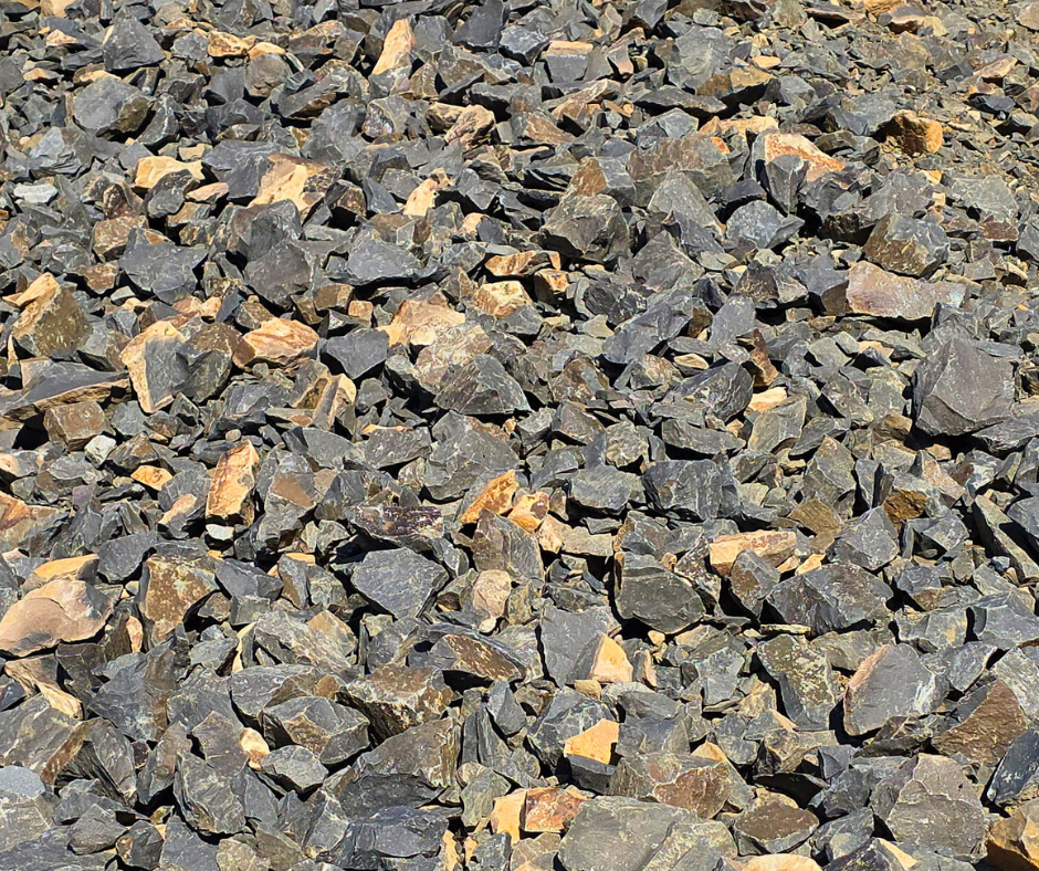 Close-up of a pile of small dark gray and brown jagged rocks also called jaw run. These rocks are available at Bedrock Holdings Group quarry on Liberty Road.