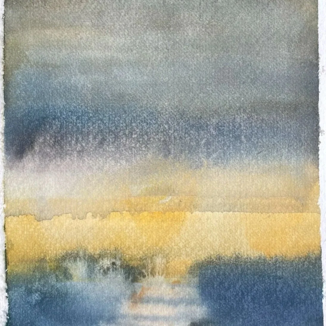 Abstract watercolor painting with blending shades of blue, gray, yellow, and hints of green, resembling a landscape or sky.