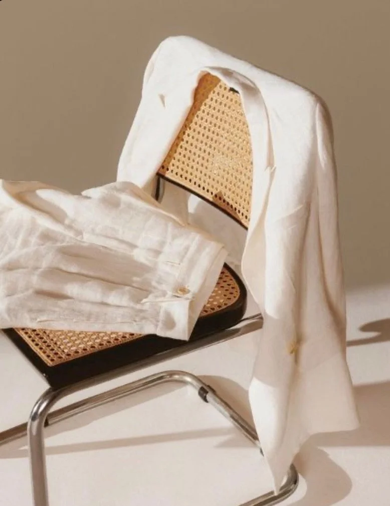 A chair with a white cloth draped over it, revealing a woven cane seat and backrest.
