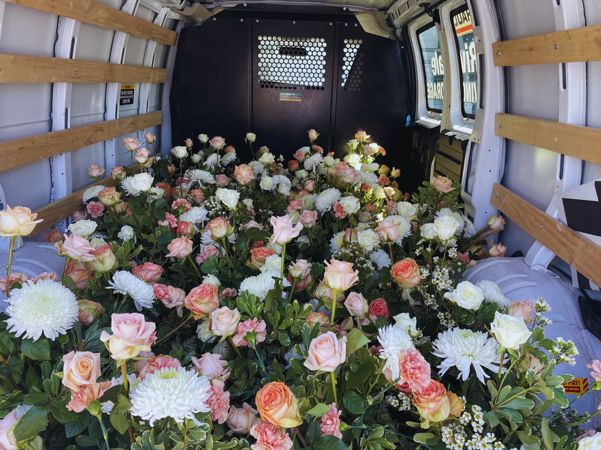 On delivery day, as we transport these beautiful blooms for the special day, we have various pink, white, and peach roses and flowers.