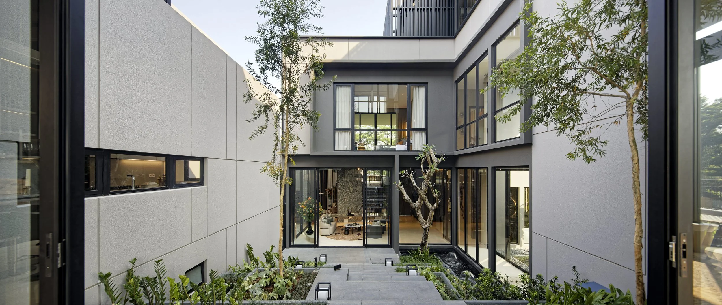 Botanic Villa central courtyard with seating area, plants and a small tree