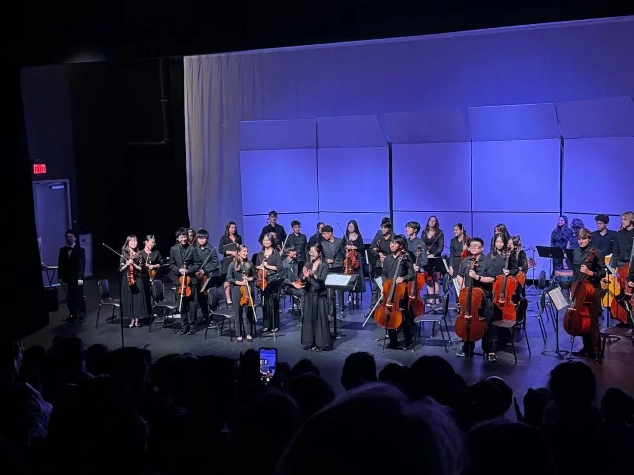 Student musicians taking a bow after chamber orchestra performance at Village High School