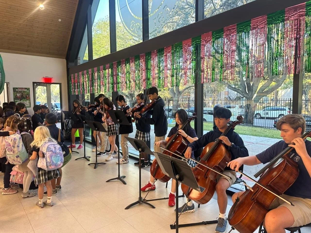 Young chamber orchestra musicians performing holiday concert with Christmas decorations