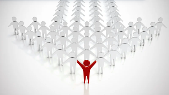 A red paper cutout of a person with arms raised, standing in front of a group of white paper cutout people holding hands, arranged in a heart shape.