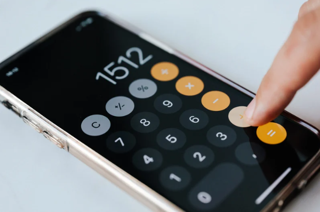 Close-up of a person's finger pressing the equals button on a smartphone calculator app.
