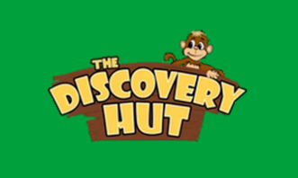 Logo for The Discovery Hut featuring a cartoon animal character on top of a wooden sign