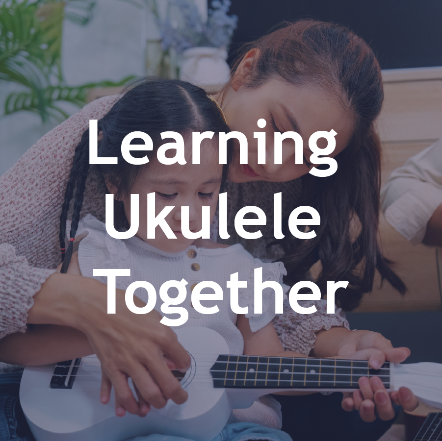 A woman helping a young girl learn to play a ukulele together in a cozy room.