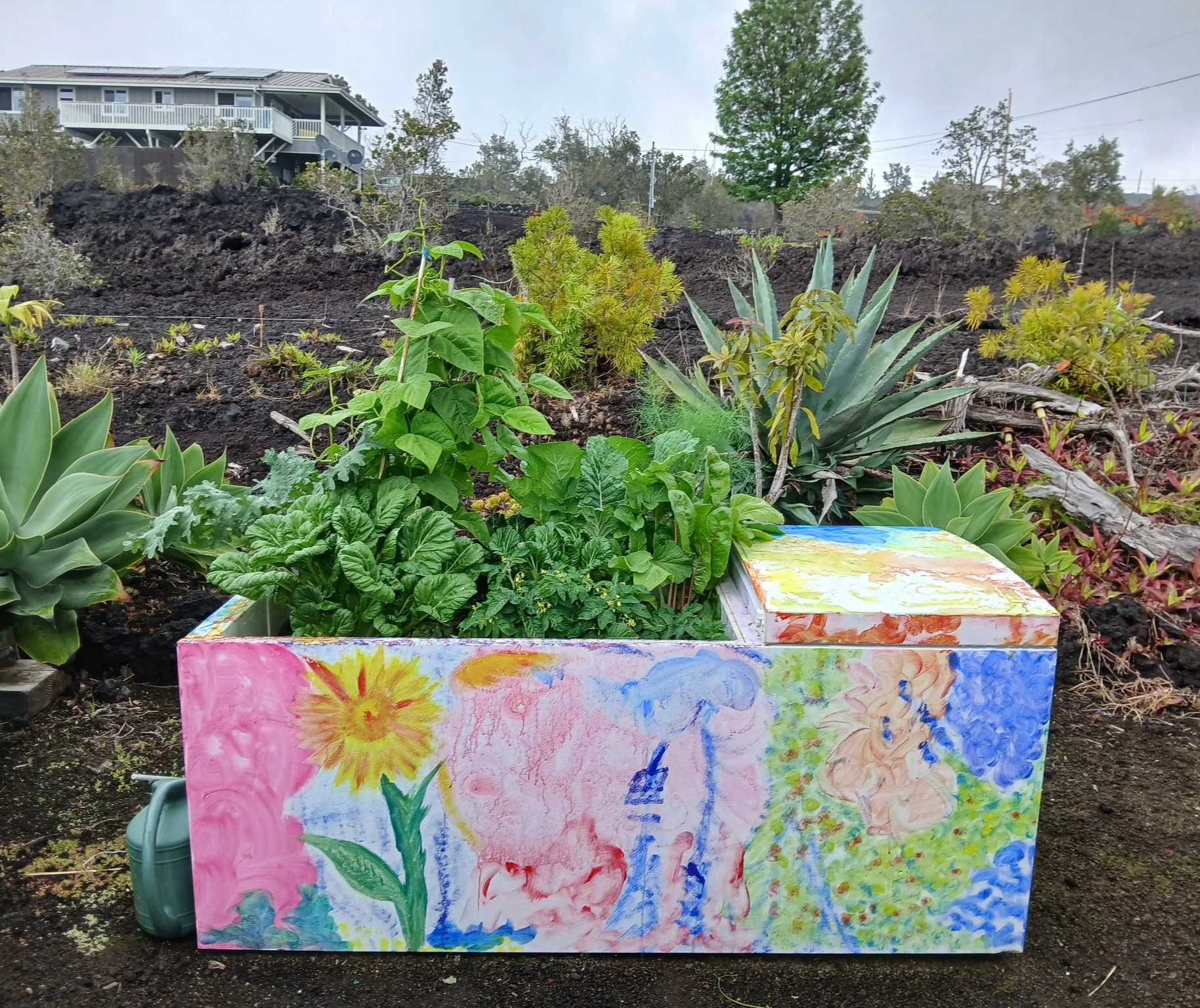 A colorful hand painted refrigerator garden, with lots of vegetables growing in it.