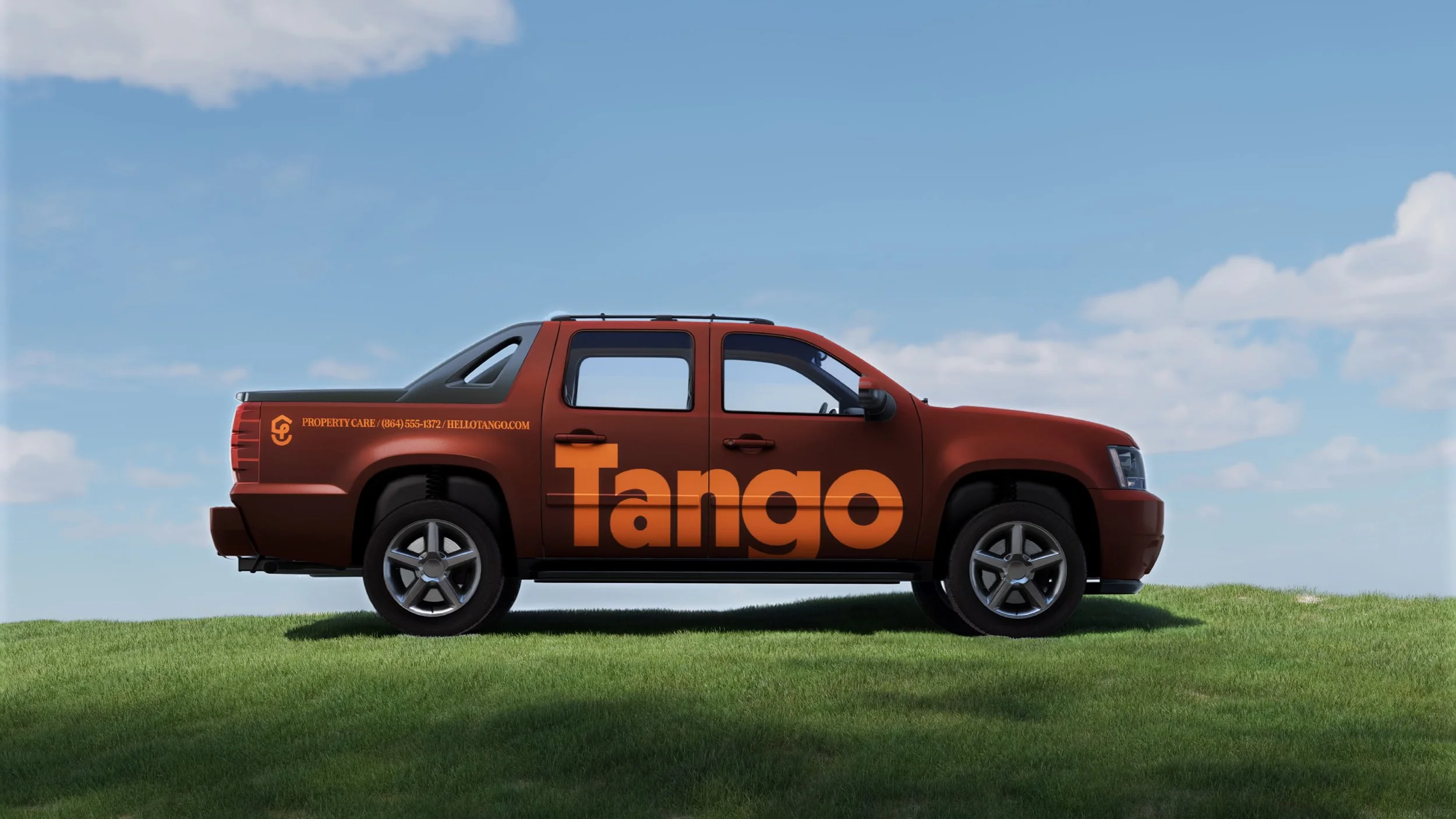 Red pickup truck with the word 'Tango' in large orange letters on the side, parked on a grassy field under a blue sky with scattered clouds.