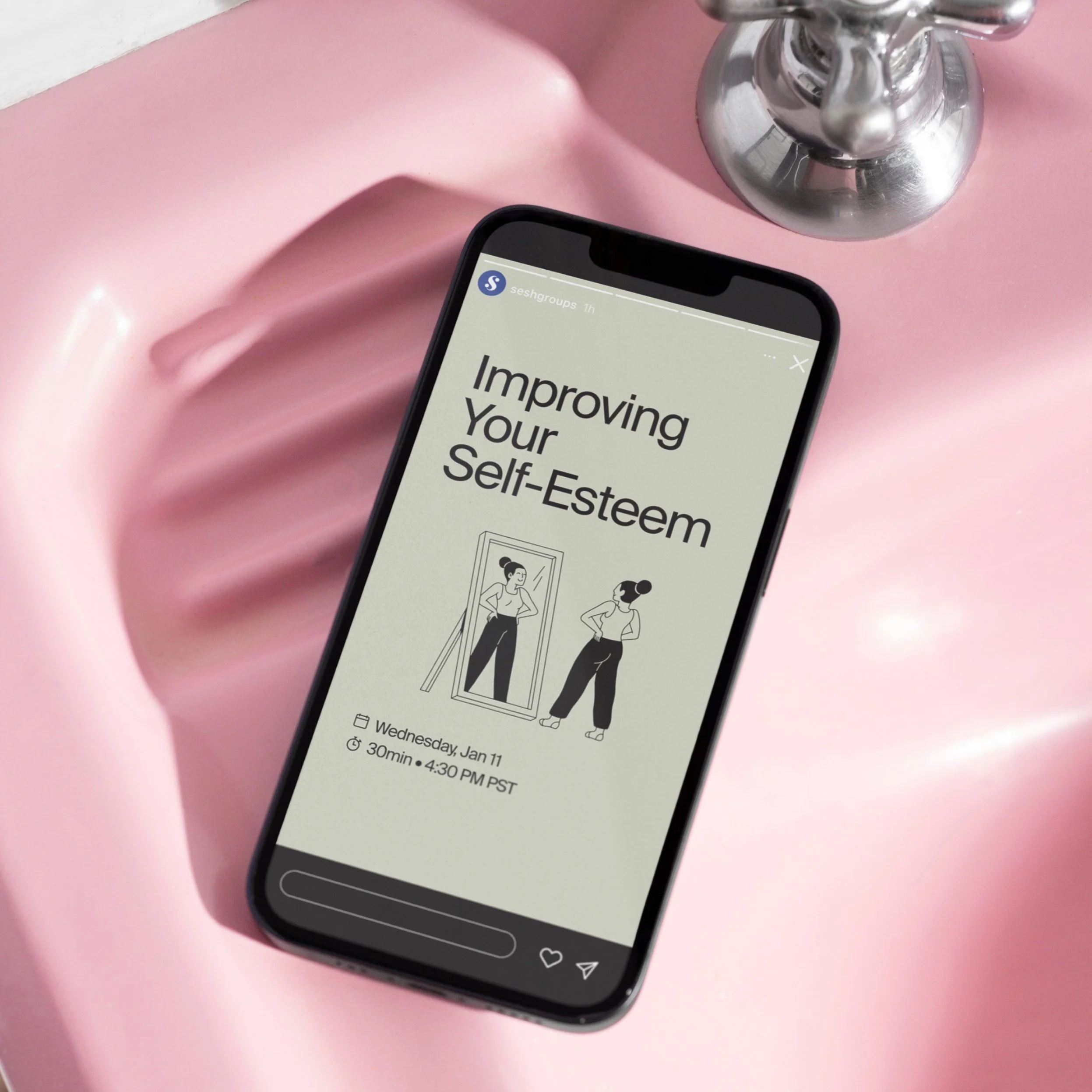 Close-up of a smartphone displaying an online self-esteem improvement session, placed on a pink surface near a silver decorative object.