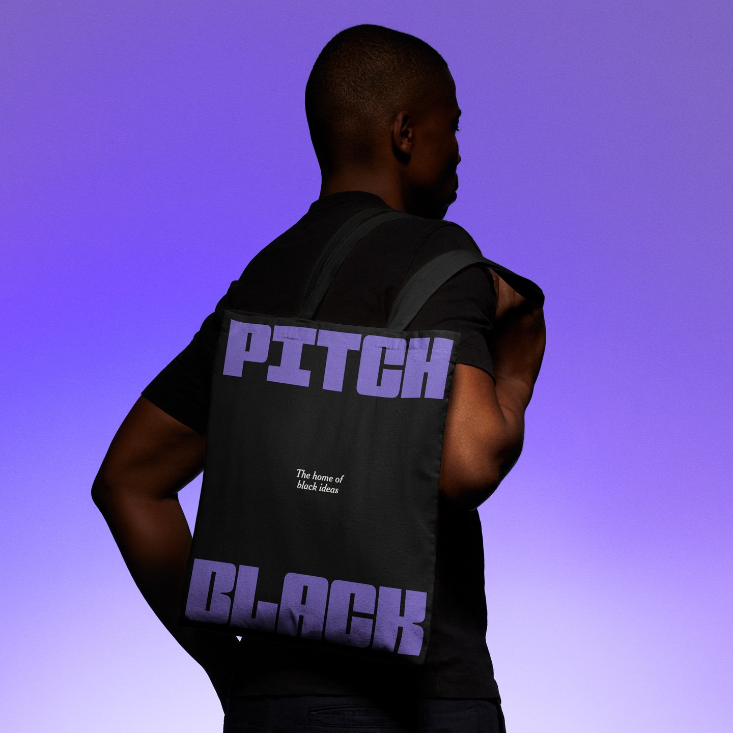 A person wearing a black shirt with the word 'PITCH' and 'BLACK' written in purple, standing against a purple gradient background.