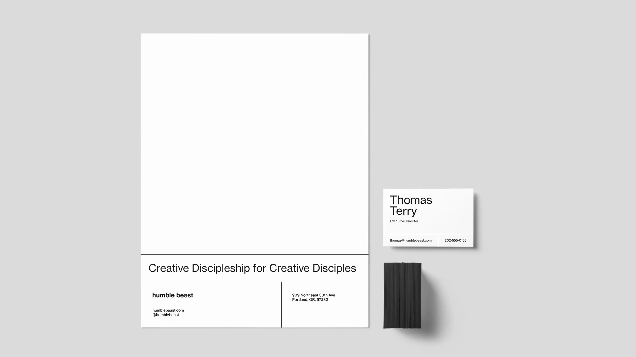 Business stationery including a letterhead and a business card for Thomas Terry, Executive Director, with contact information and address, set against a plain gray background.