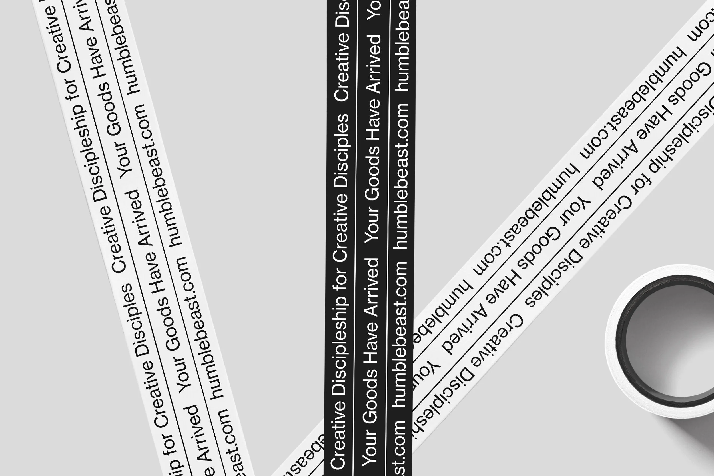 Close-up of a roll of adhesive tape with printed warning labels, partially unrolled with the remaining tape on the roll.