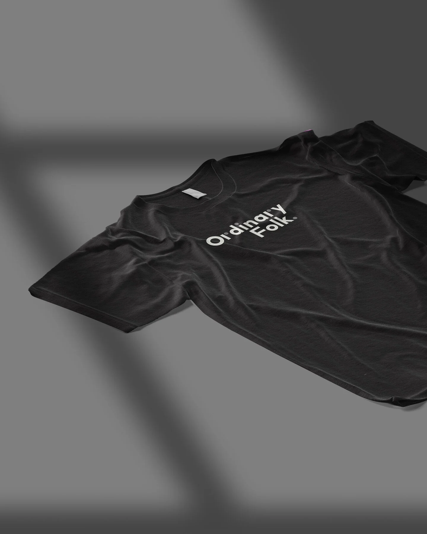 Black T-shirt with white text that reads 'Ai-y Folk' laid flat on a gray surface.
