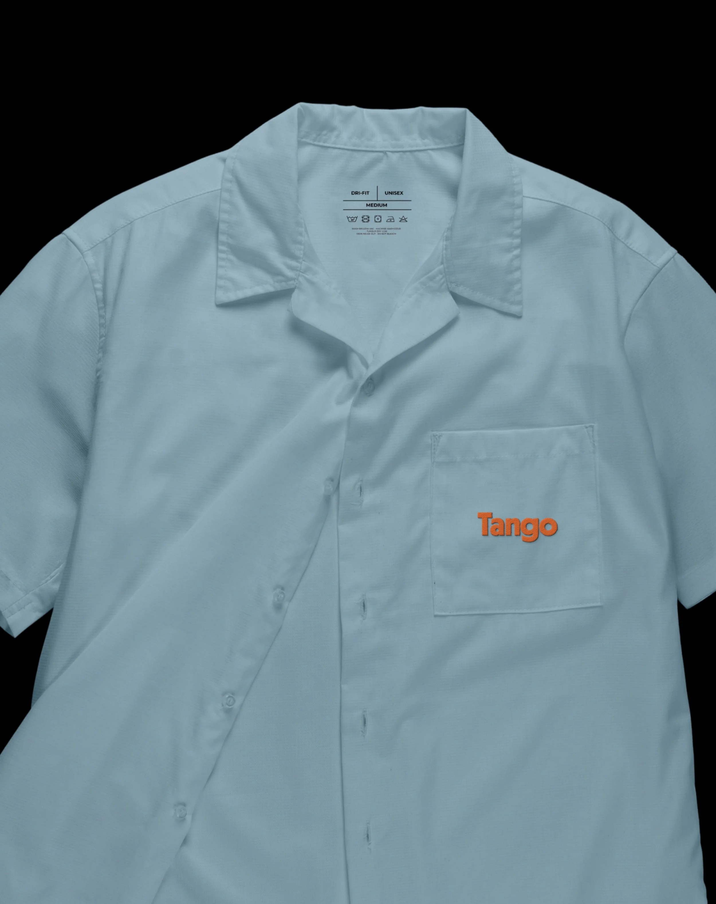 A light blue short-sleeve button-up shirt with a collar, featuring an orange embroidered logo that reads 'Tango' on the lower right side, set against a black background.