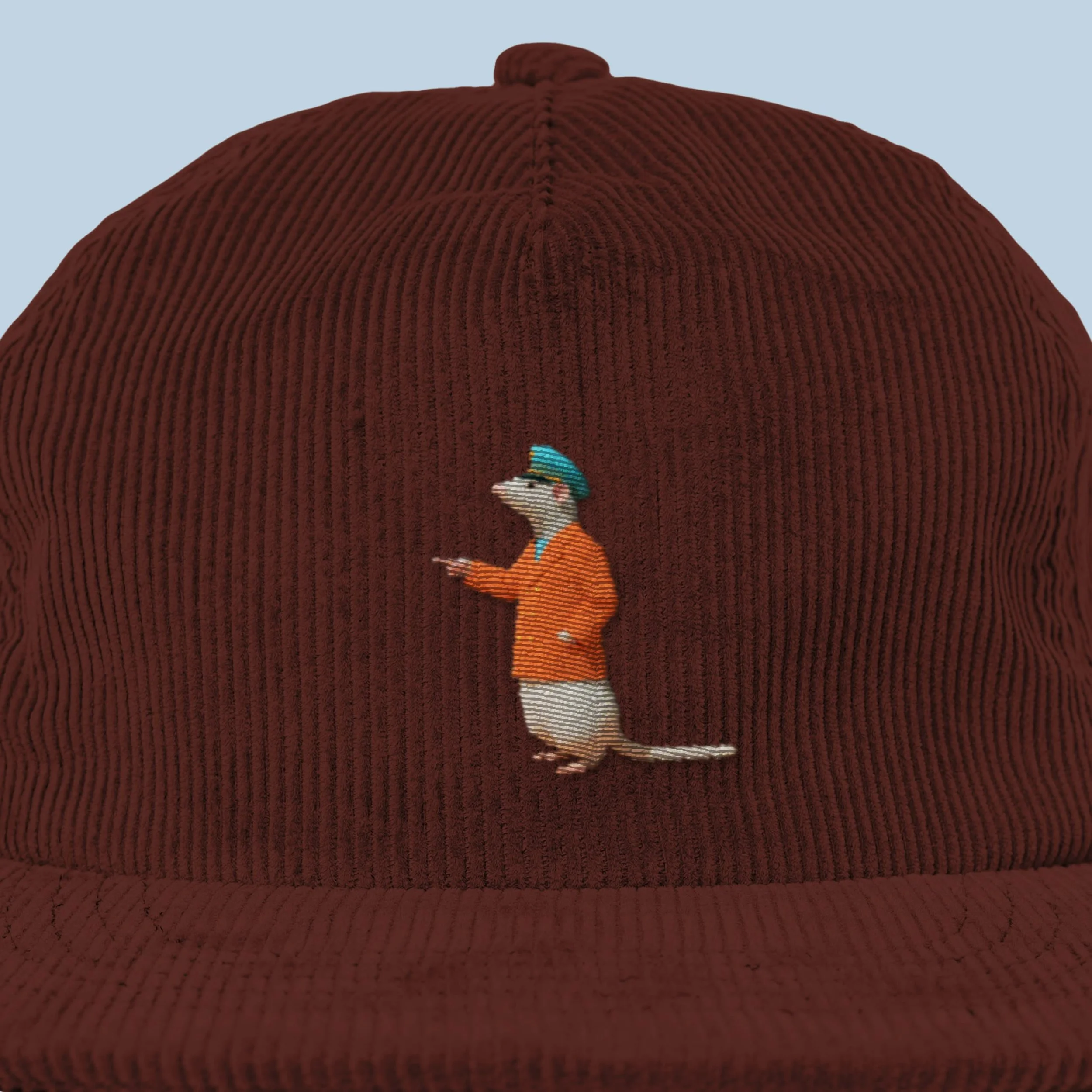 A person wearing an orange shirt with white stripes, blue hat with green accents, and glasses, standing against a backdrop of large, brown, textured fabric that covers most of the background.