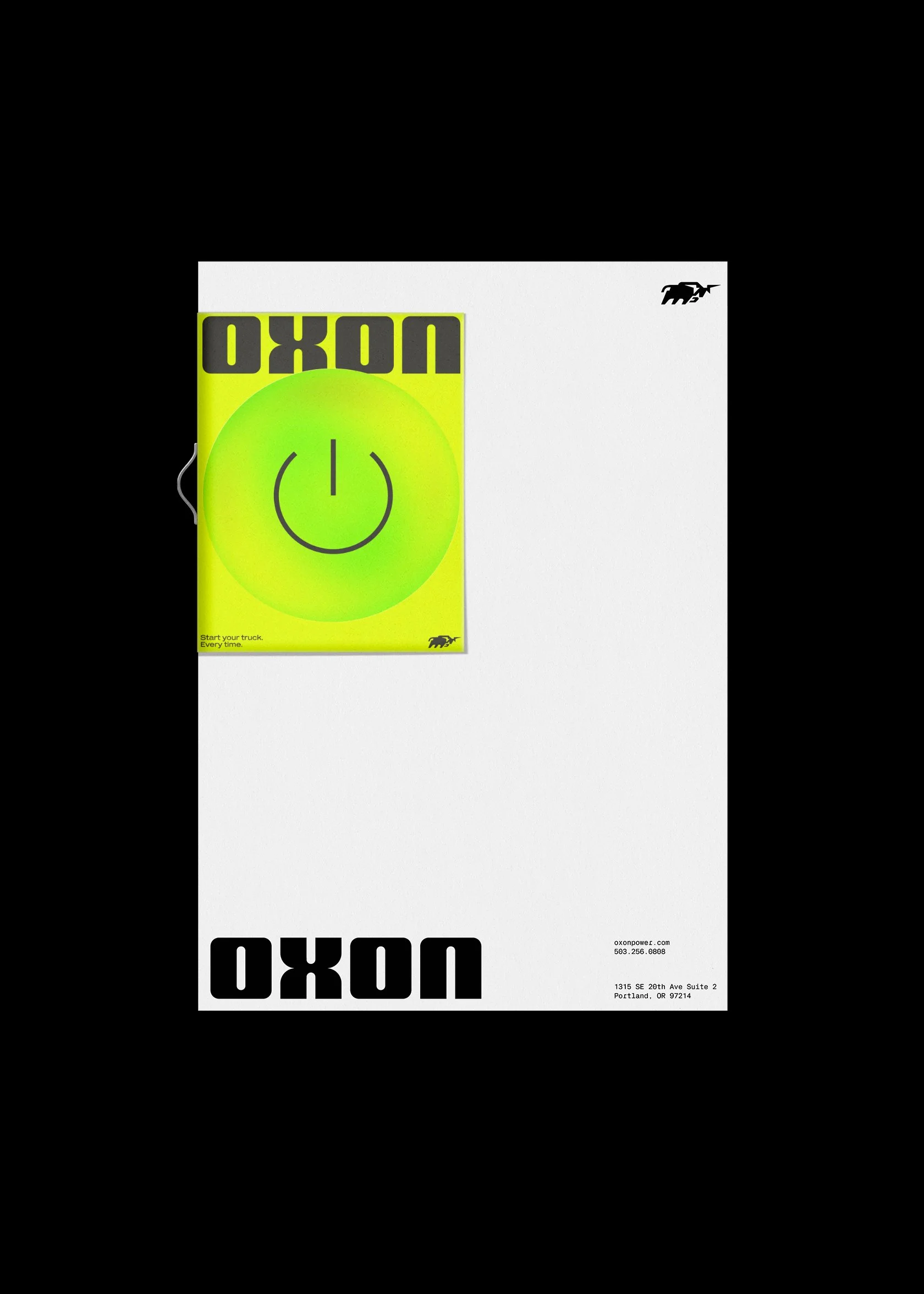 A bright yellow and green sticker with a smiley face and the word 'UOXO' repeated upside down, placed on a white piece of paper with black text and a small animal logo, on a black background.