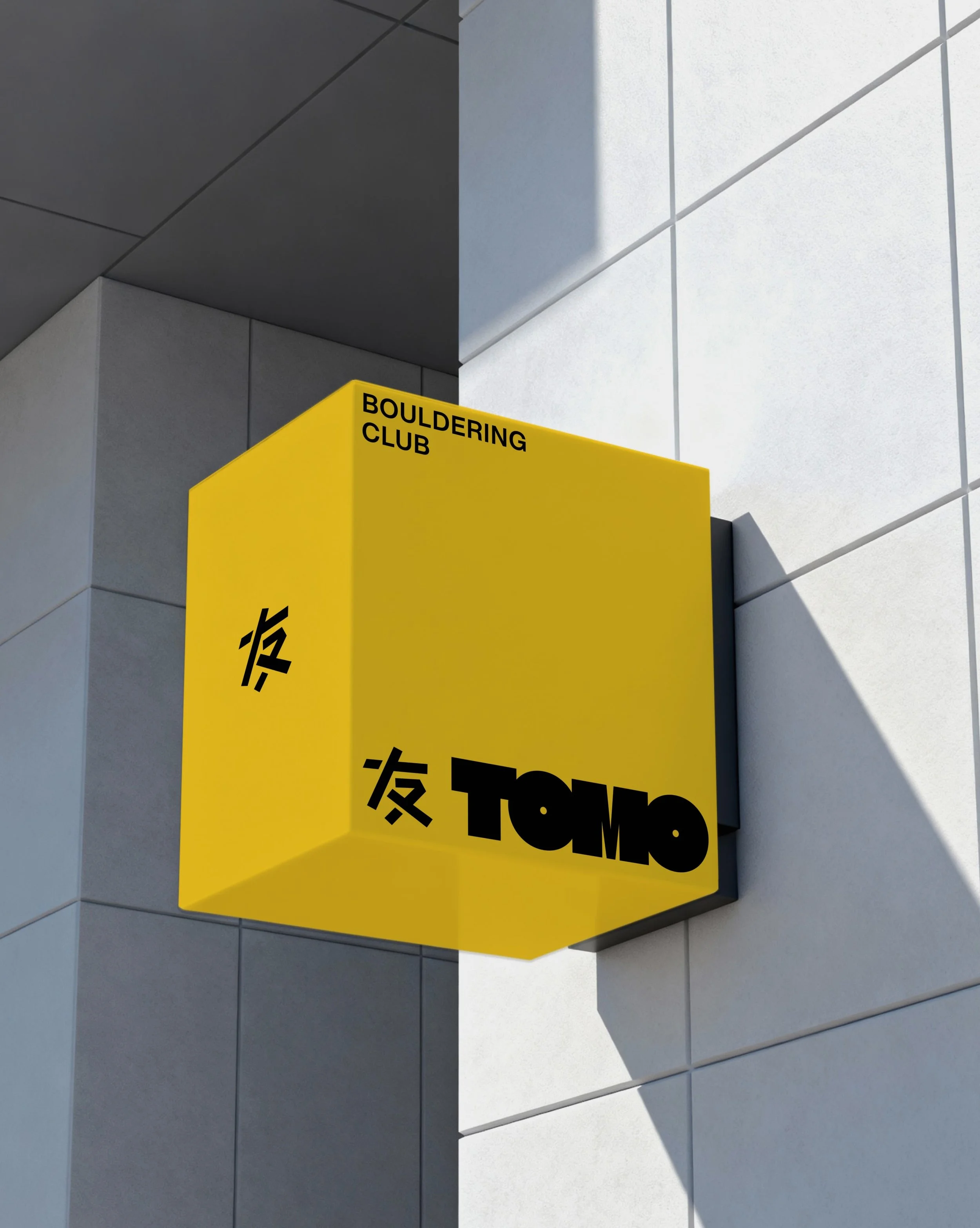 A building exterior with a yellow sign that reads 'BOULDERING CLUB' on a corner wall, and part of the wall is light gray. The image is divided into two halves, one showing the wall in darkness and the other in brightness, creating a split effect.