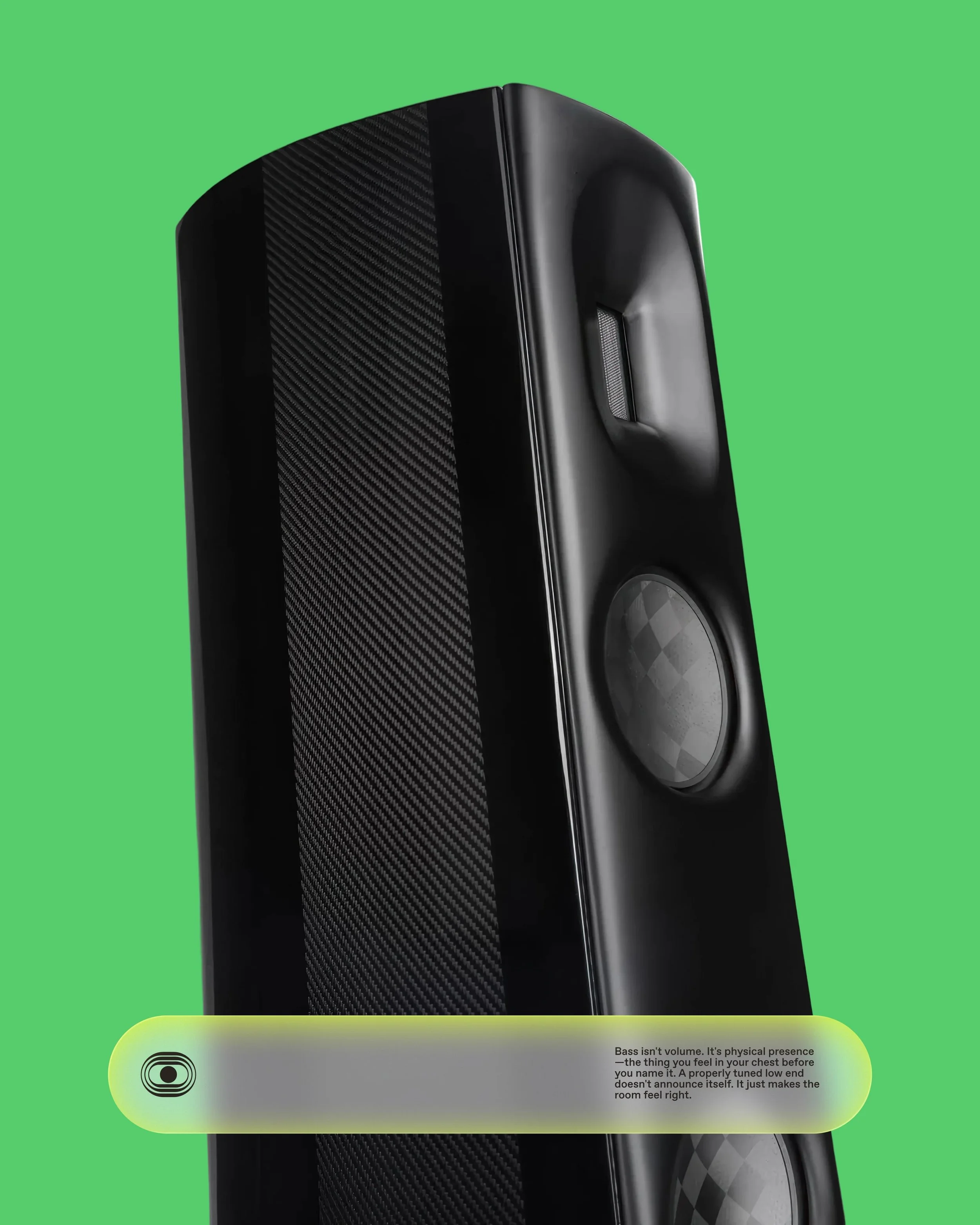 Close-up of a black speaker with a textured front grille and a sleek design, set against a bright green background.