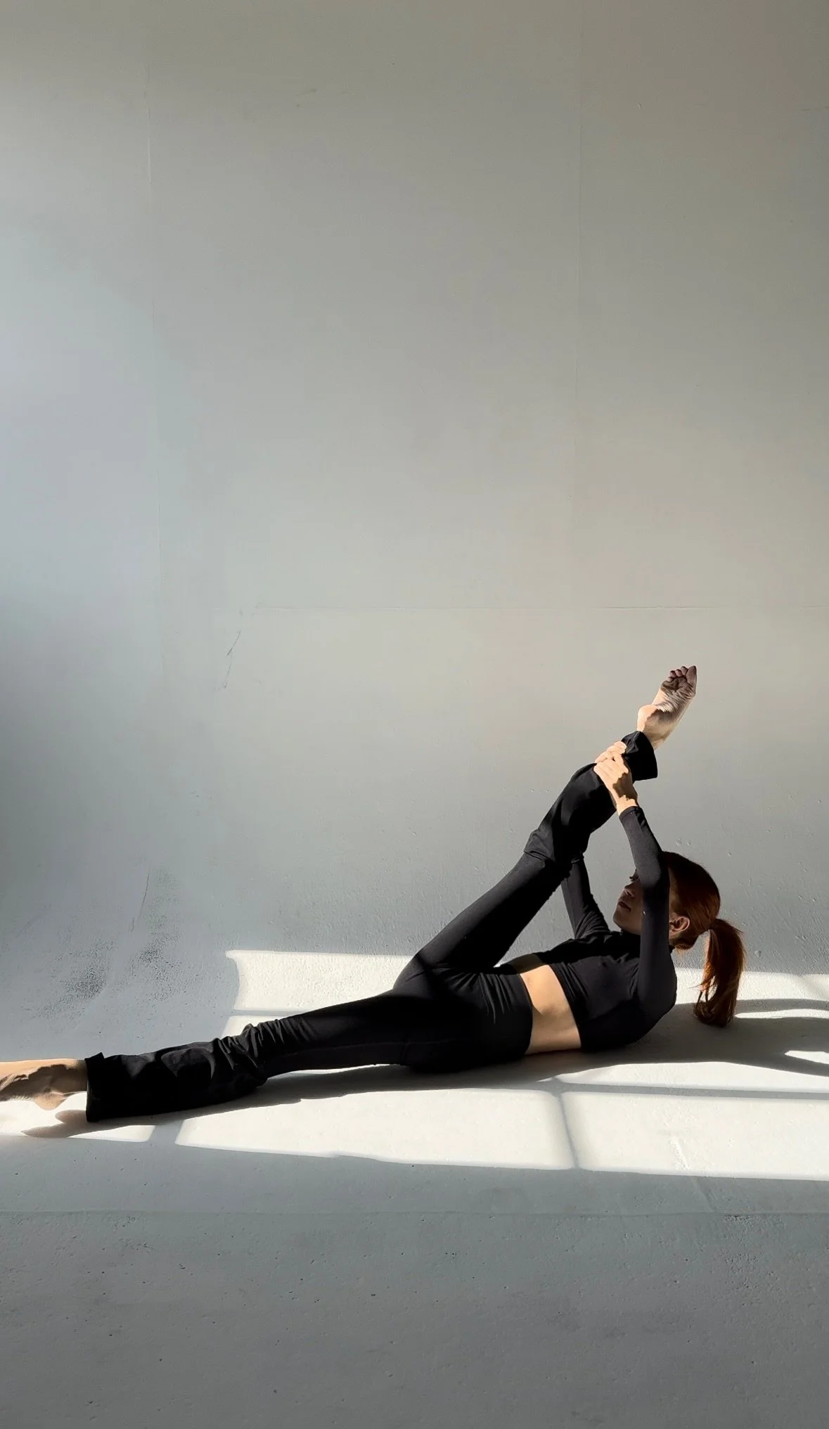 Emily of the Em Effect demonstrating Single Straight Leg Stretch exercise of Classical Pilates Series of 5