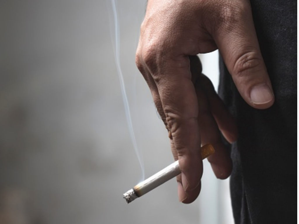 hand holding cigarette representing how smoking constricts blood vessels and reduces circulation