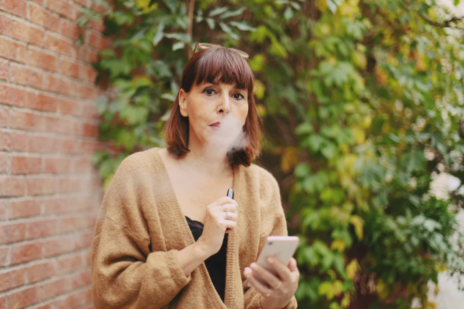 woman using vape device illustrating how vaping and nicotine can damage blood vessels and circulation