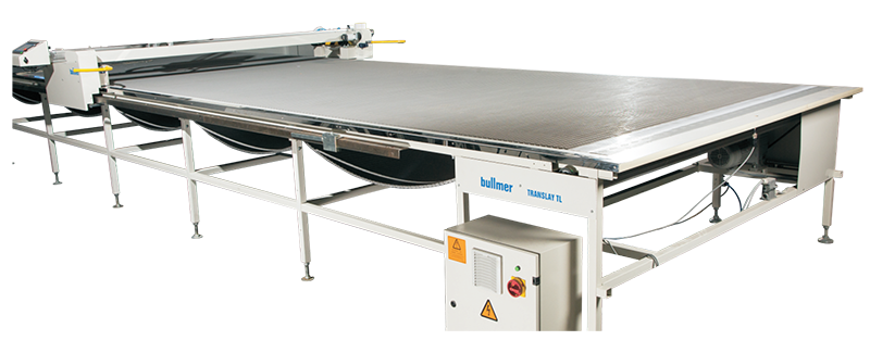 Large industrial flatbed conveyor or material handling table with metal frame and control box.