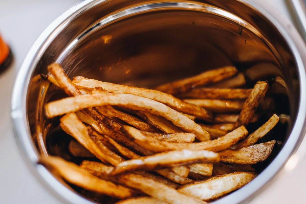 French fries inside an open stainless steel air mixing bowl.