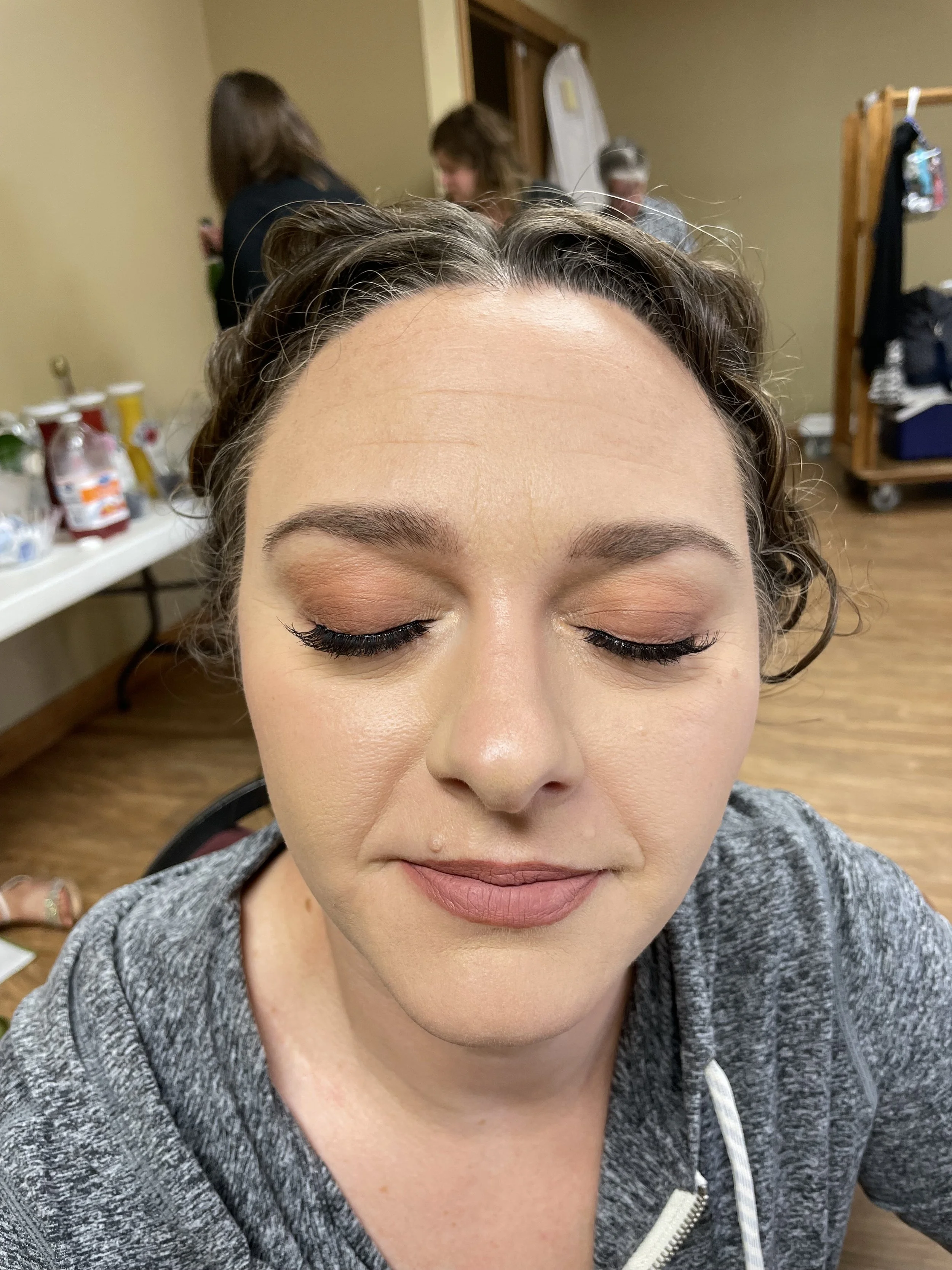 Close-up of a bridesmaid with makeup, eyes closed.