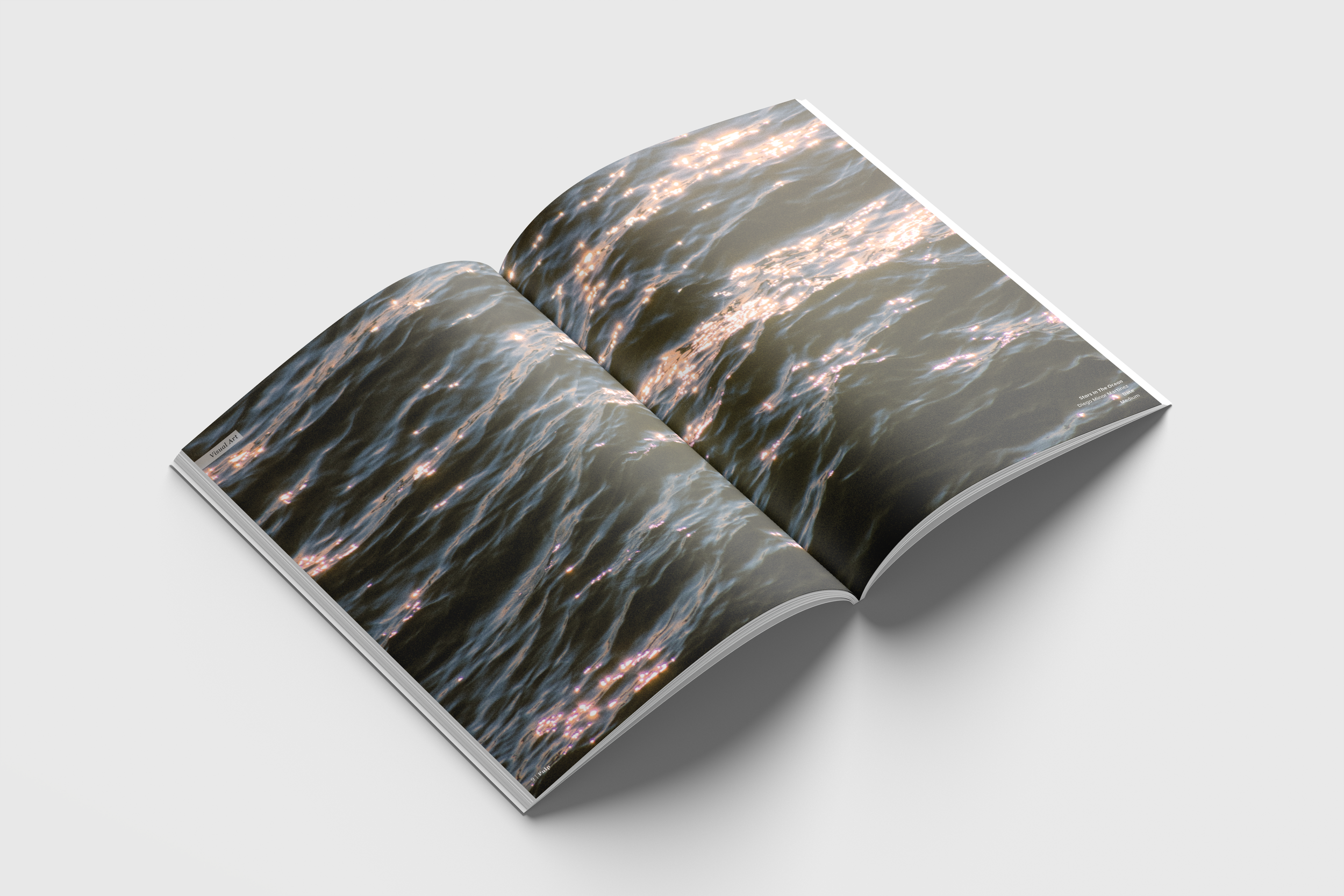 Open magazine showing a photo of water with sunlight reflections.