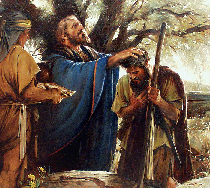 A biblical scene where Jesus is anointing a man's head while another man appears to be praying, with a woman holding a jar nearby. They are outdoors under a large tree.