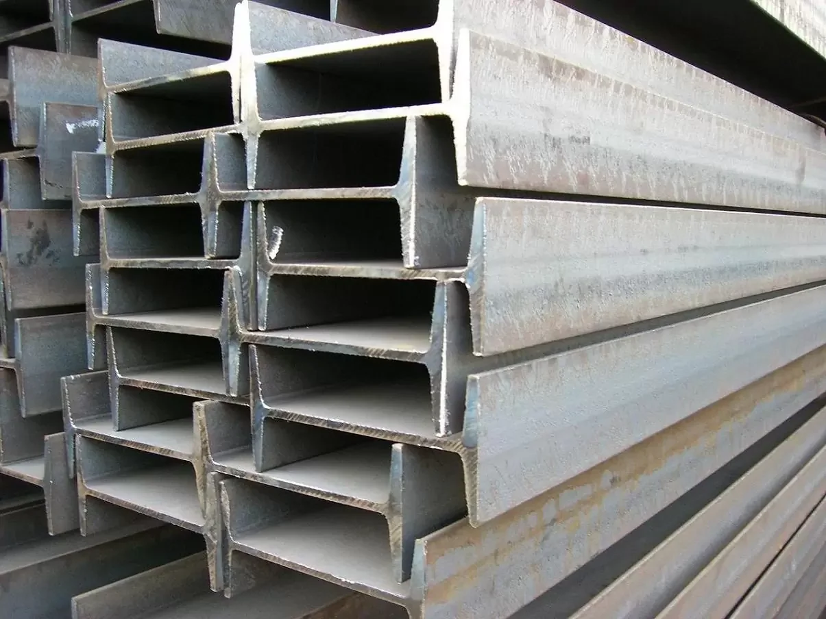Stacked metal I-beams in an industrial setting.