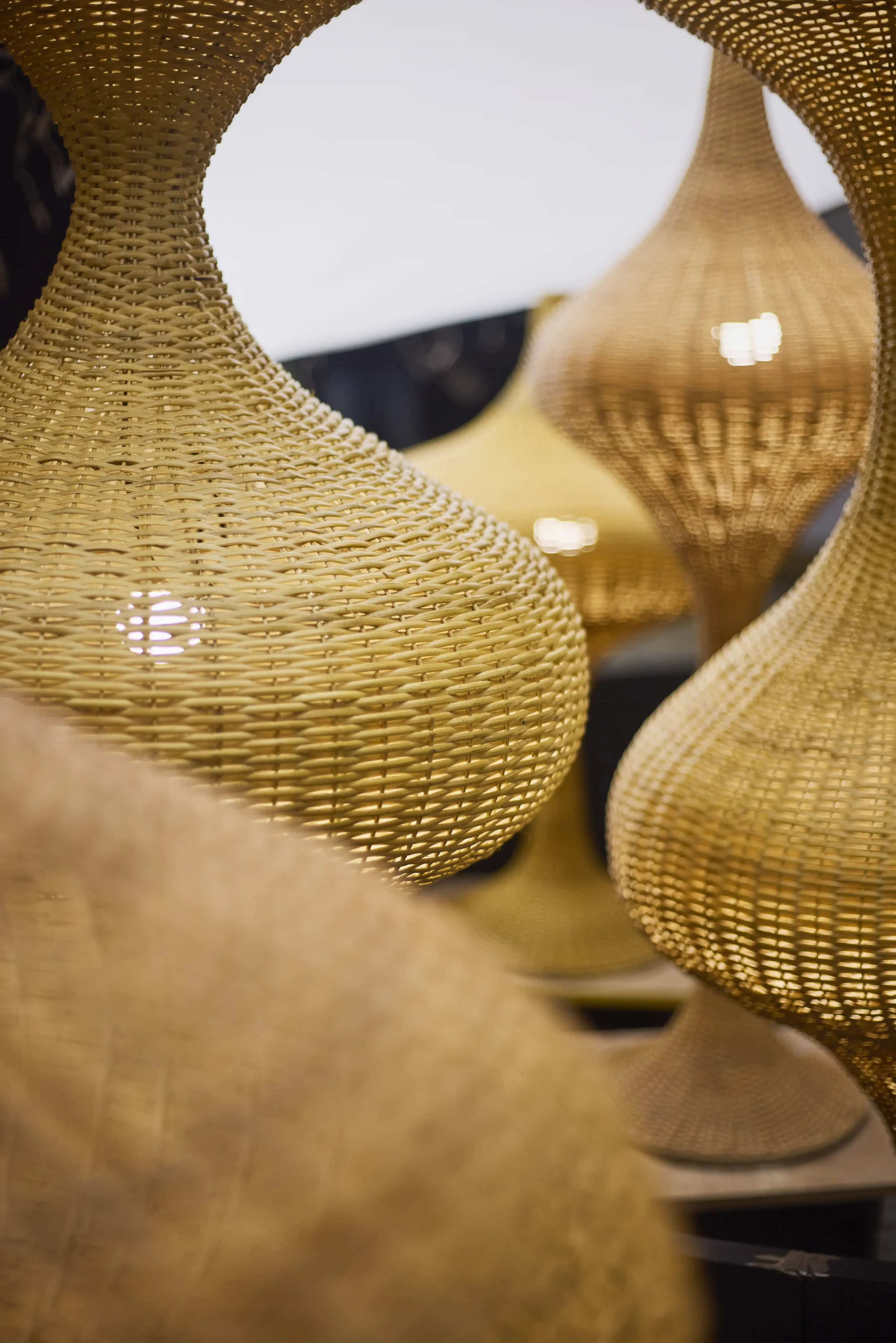 Close-up of woven rattan pendant lamps hanging from the ceiling.