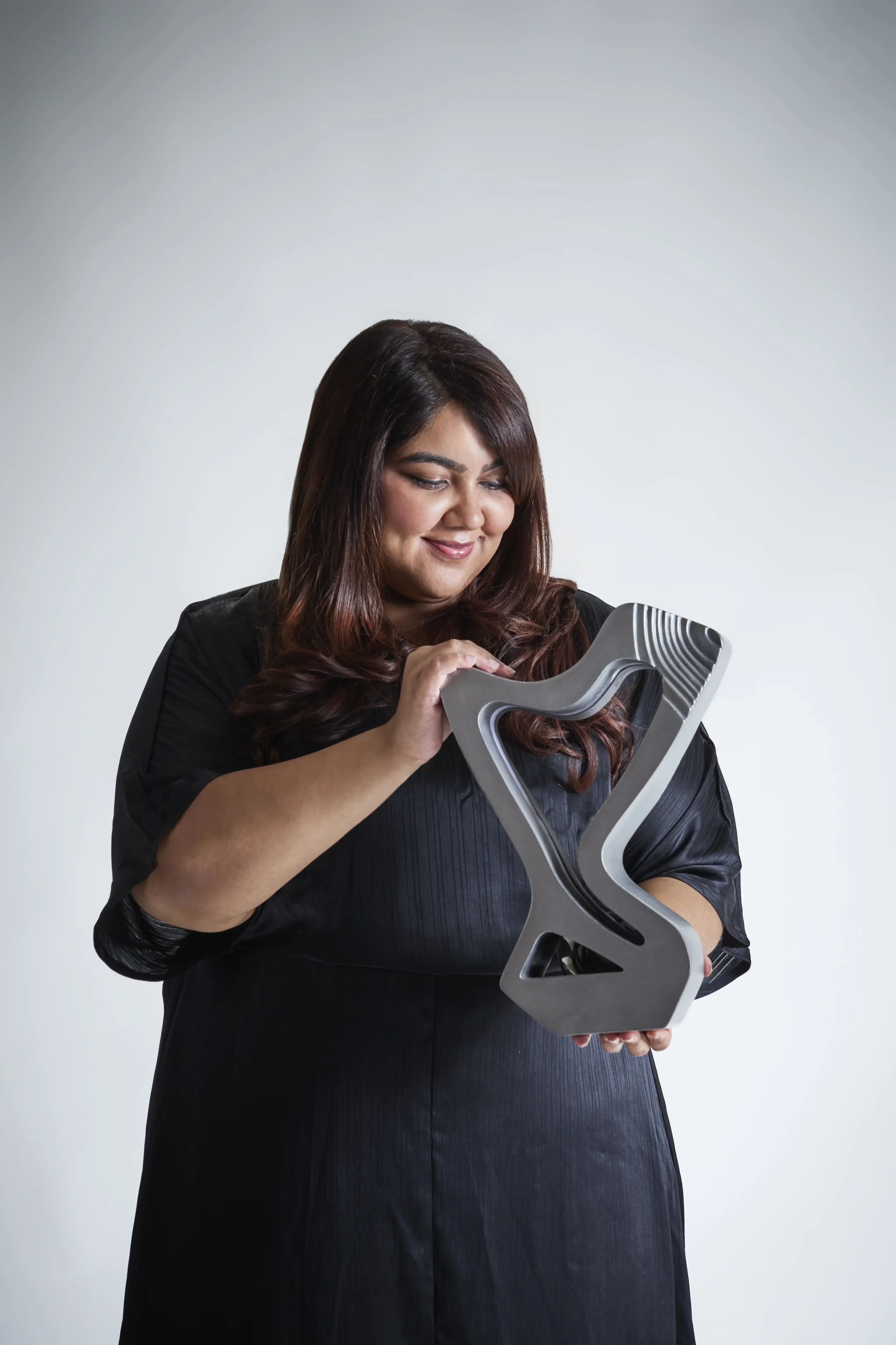 Woman holding and admiring a modern sculpture