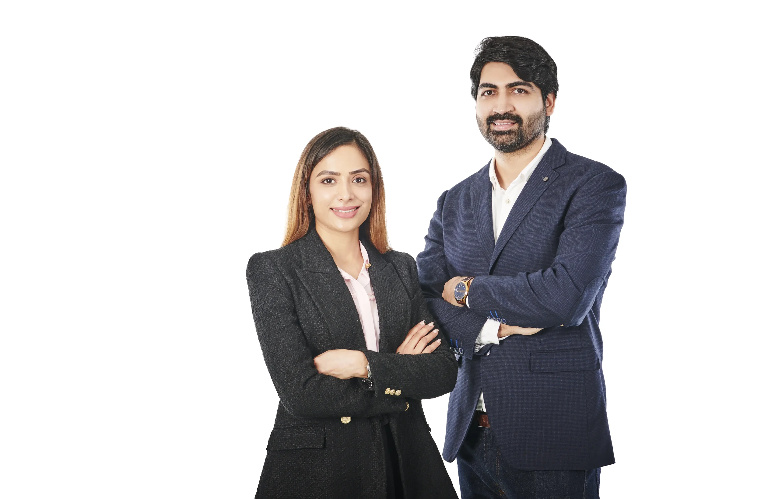 A man and woman standing together with arms crossed, dressed in professional business attire, smiling at the camera, against a plain white background.