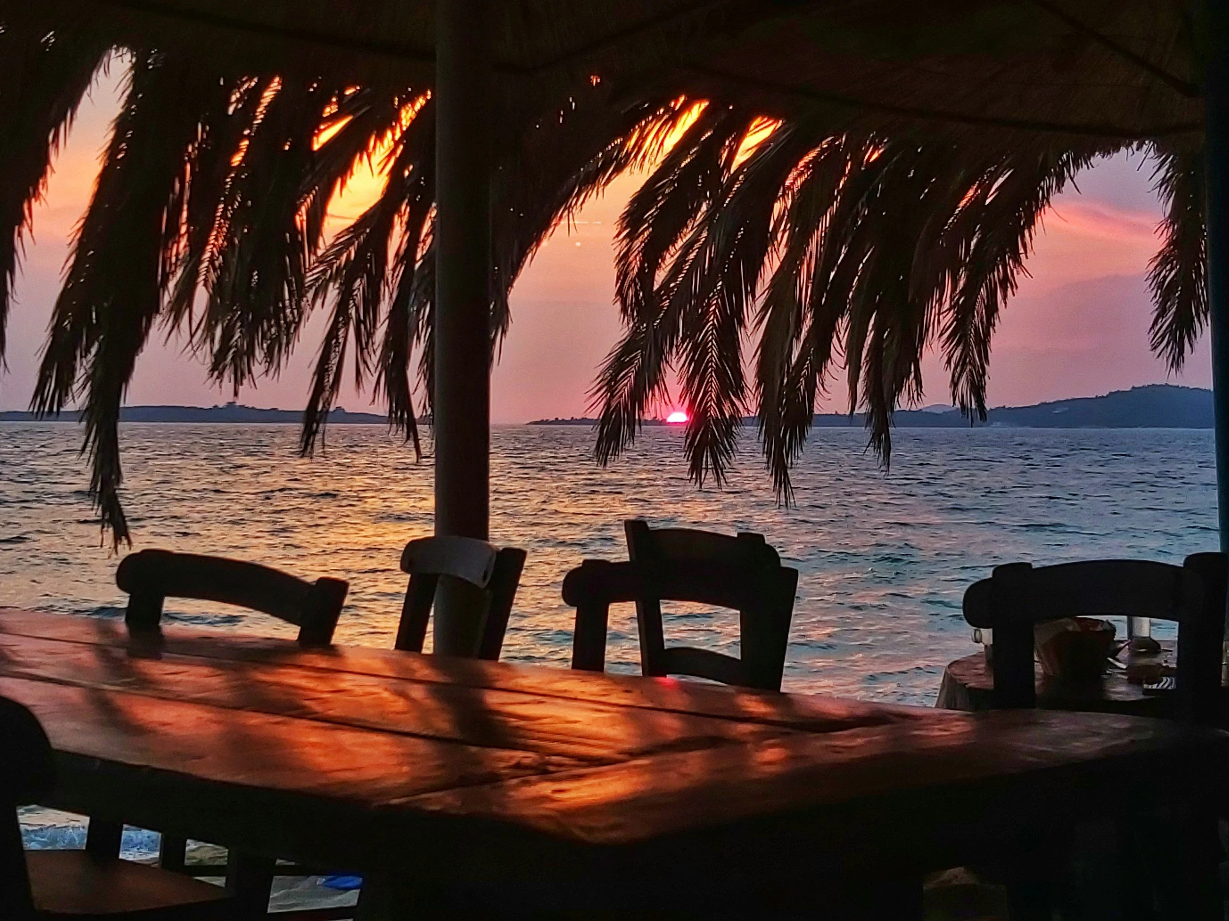 Sun setting behind a seaside tavern in Crete.