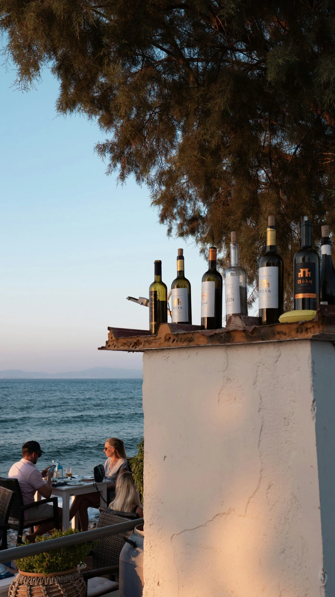 Wine bottles on a tavern wall near the sea in Crete.