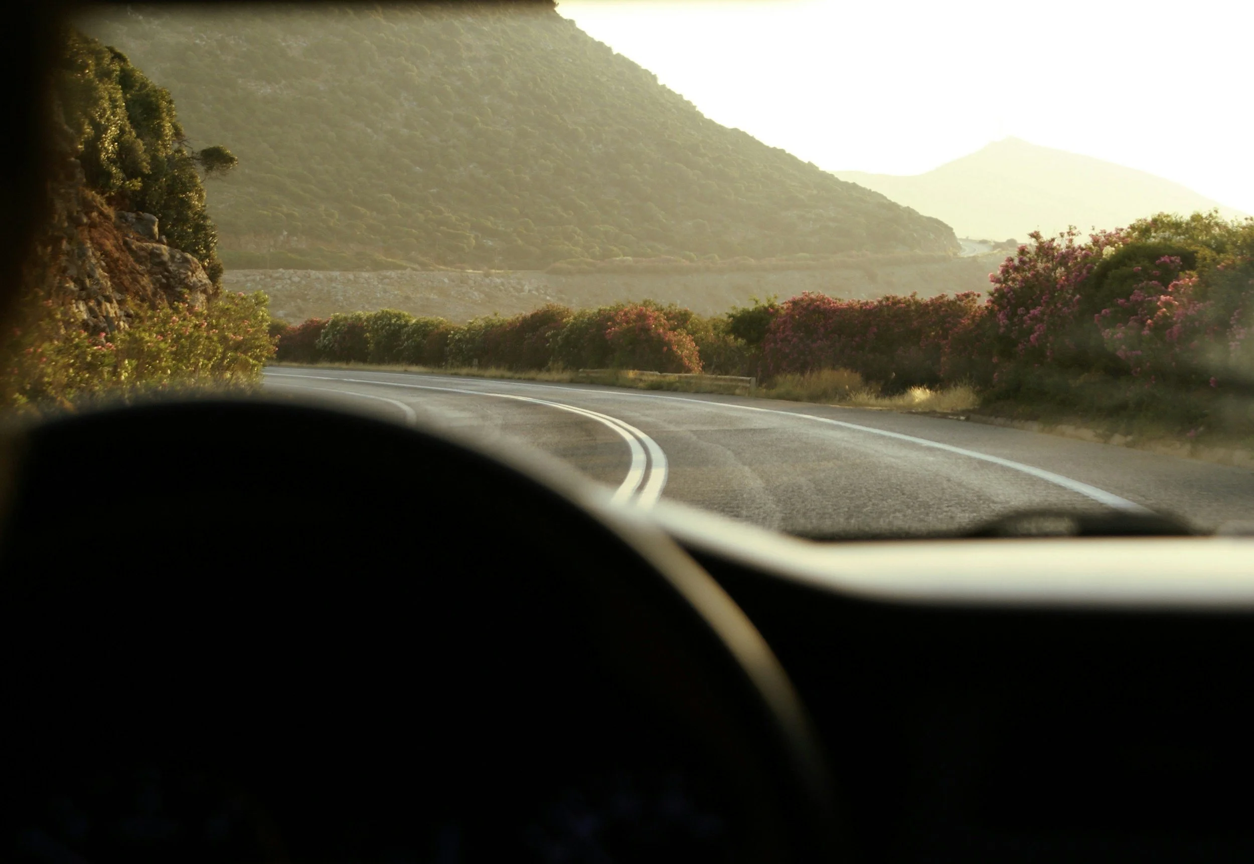 View through front window of a car driving in South Crete in the mountains.
