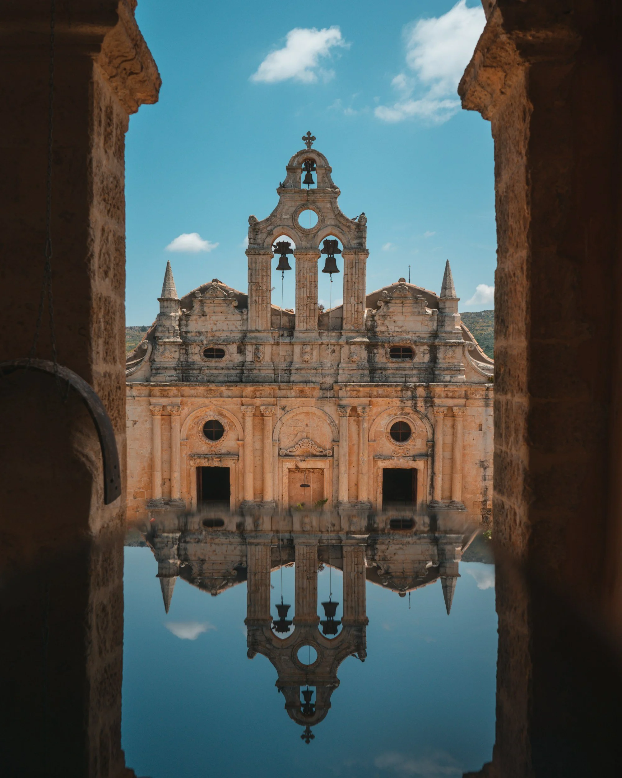 Facade of Arkadi Monastery in Crete reflected in a pool of water.