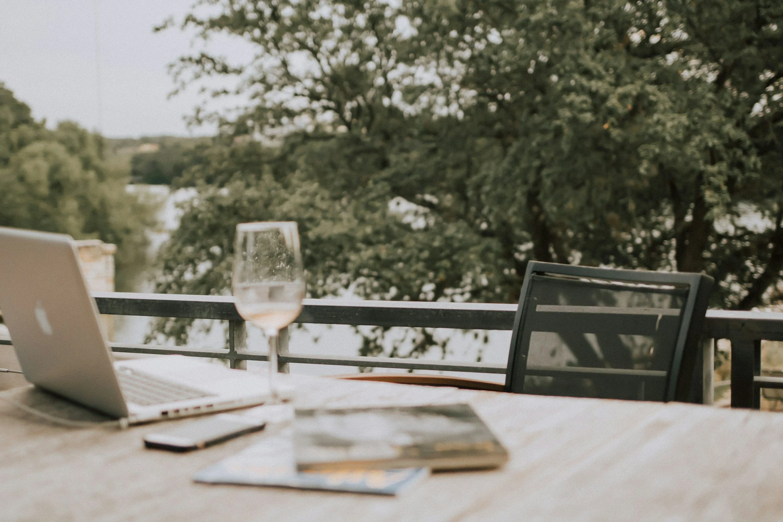 A table with open laptop and wine glass during a workation in Crete.