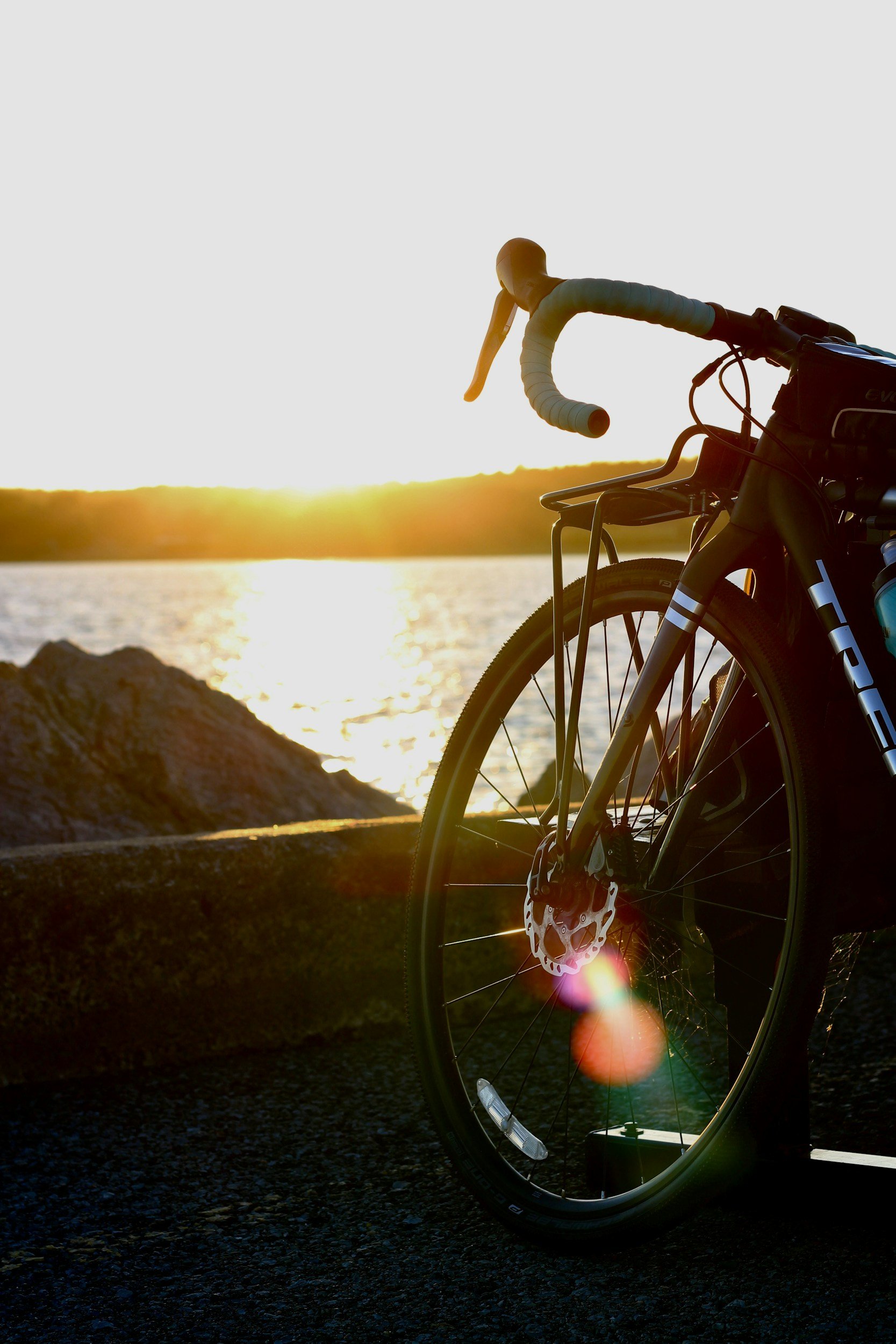Front of a bicycle parked in front of Lake Kournas, Crete, during sunset.