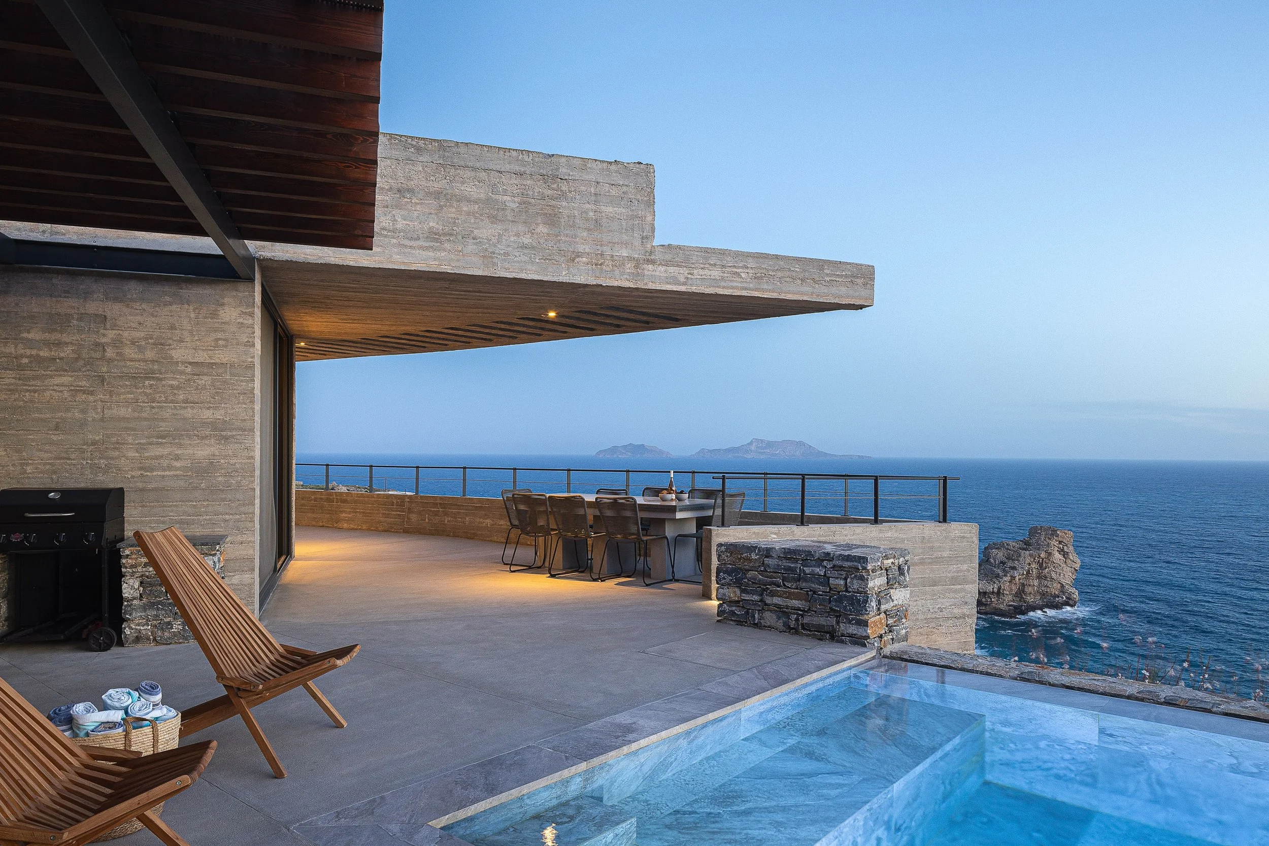 Eulimene villa in Agios Pavlos above Aniforas Bay with infinity pool at sunset, overlooking the calm Libyan Sea and open coastal horizon.