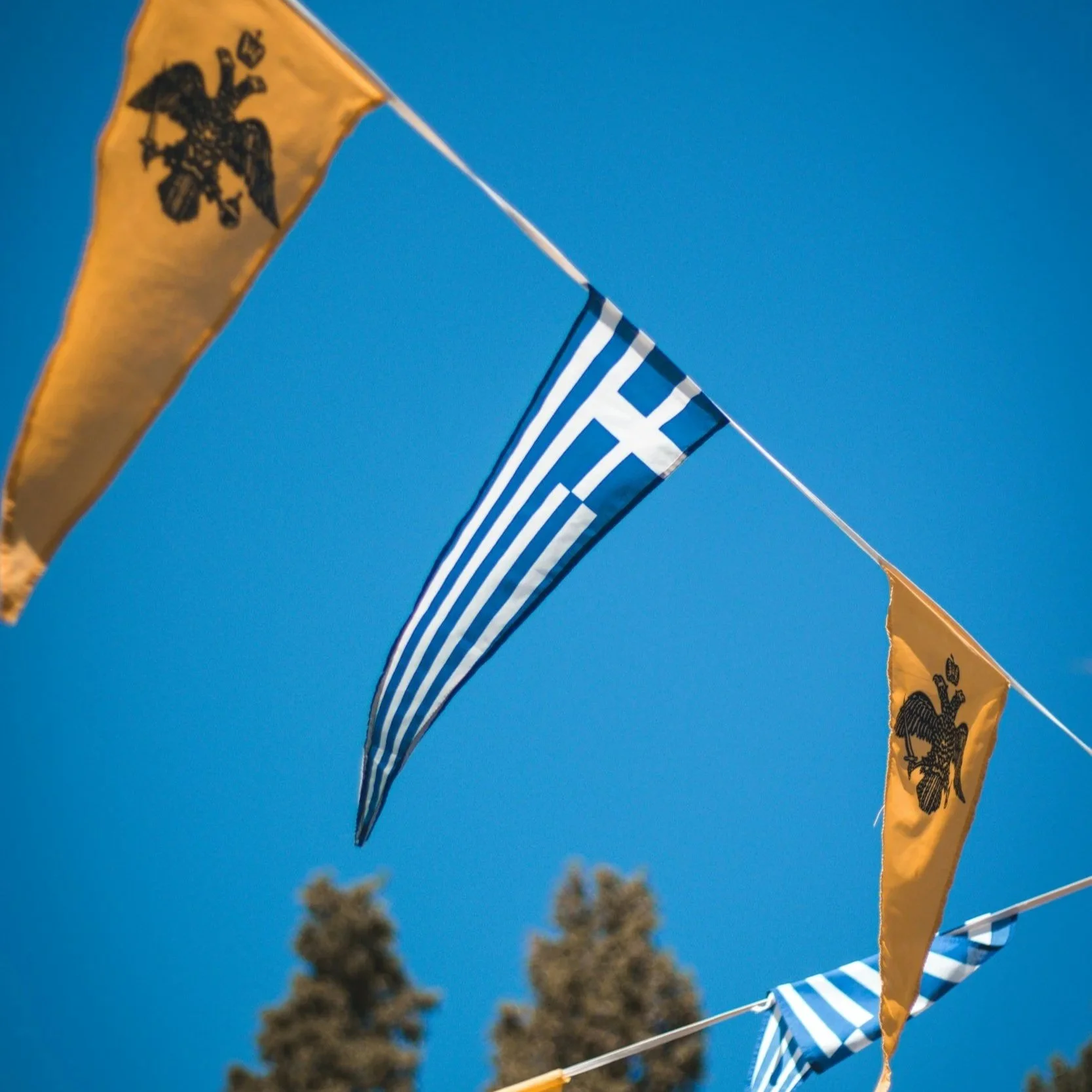 Triangular Greek flags lined up on a string for a festival in South Crete.