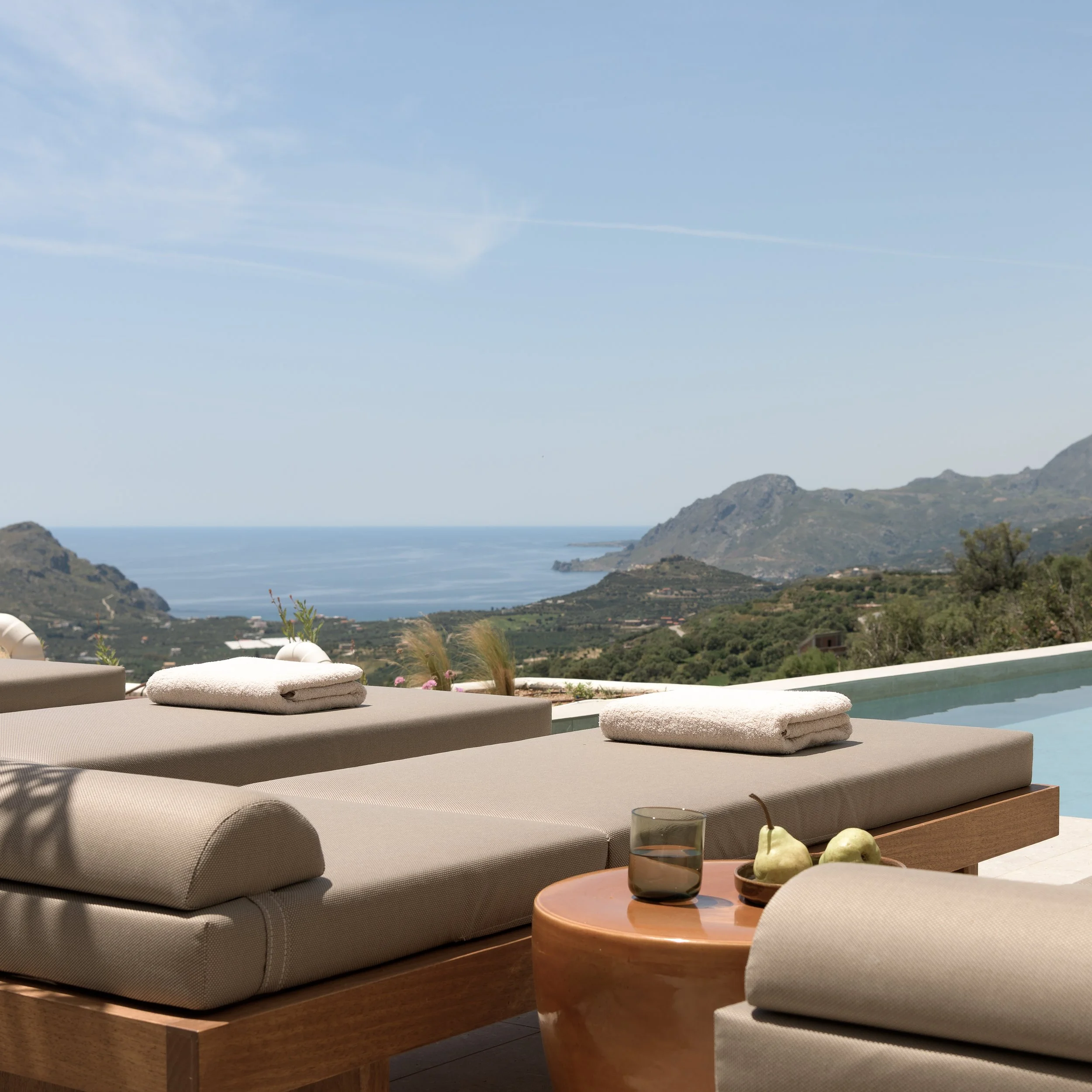 Sun loungers and infinity pool terrace at Sto Lofo overlooking Plakias Bay and the South Crete coastline.