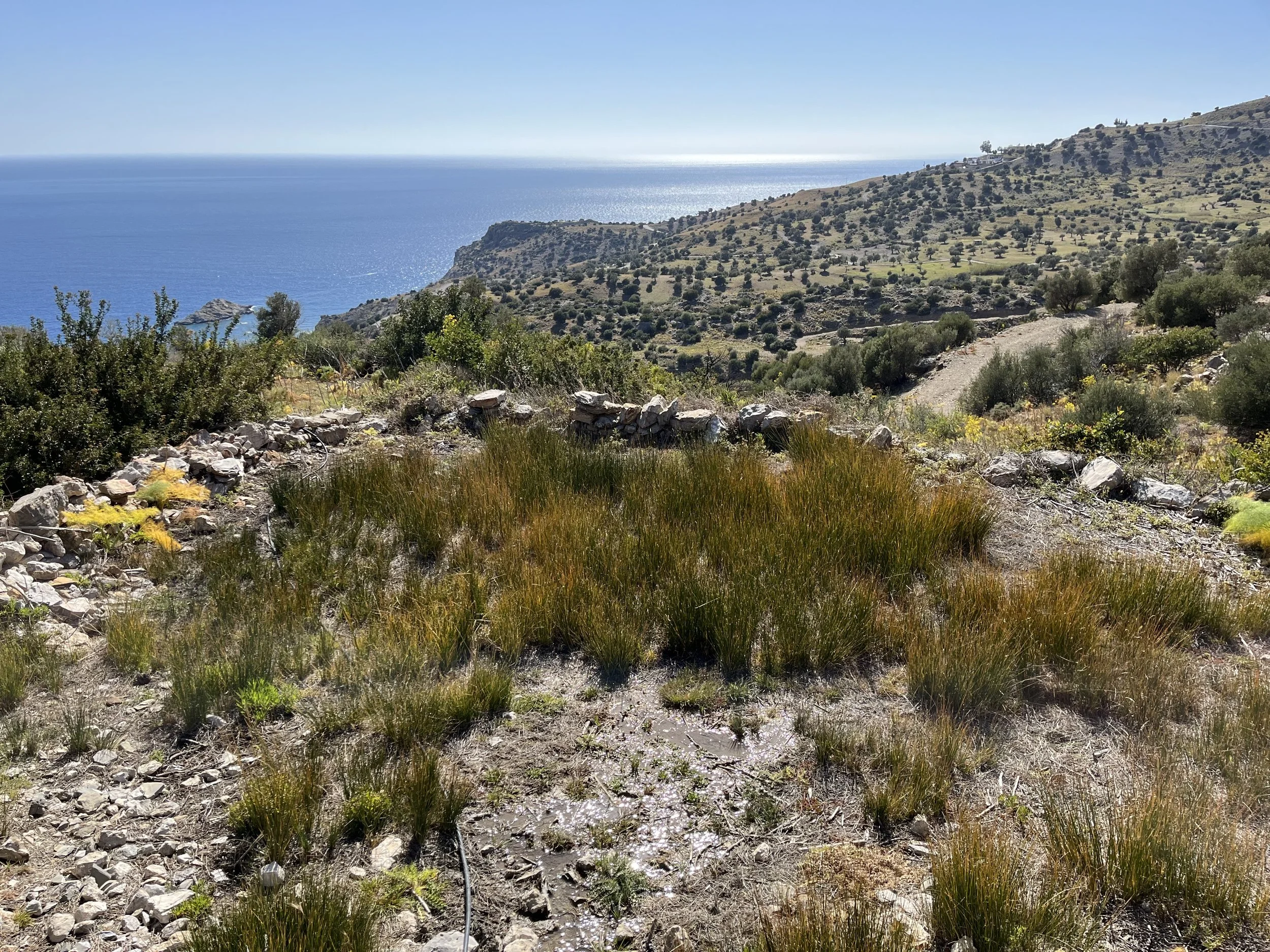 Stone ruins of the ancient refuge settlement near Agios Ioannis in South Crete overlooking the Libyan Sea and rugged mountain landscape.